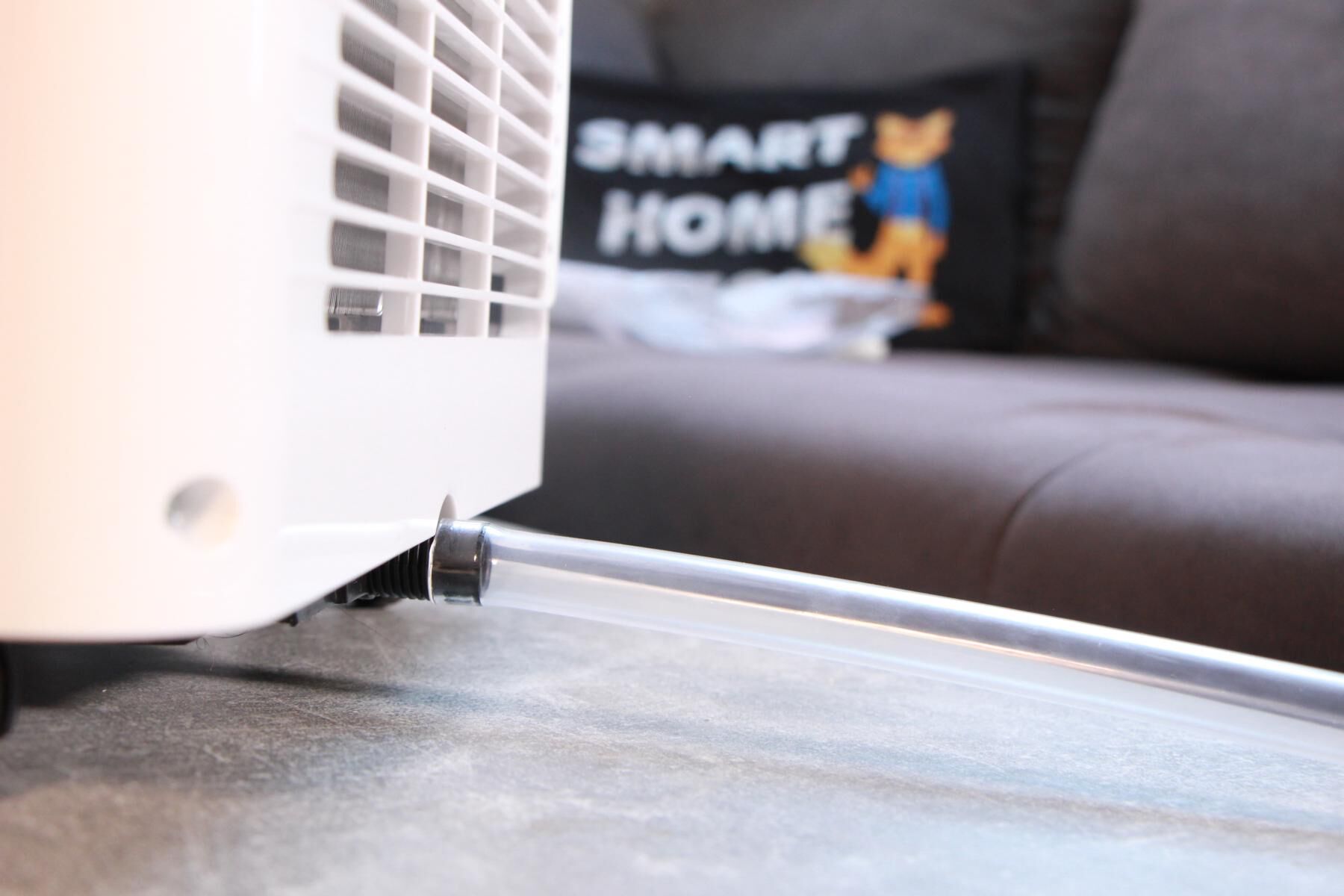 Der Wassertank einer mobilen Klimaanlage wird im Test mit Hilfe eines Ablaufschlauchs entleert